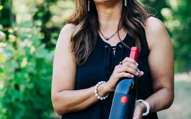 Woman holding a bottle of Dot Wine
