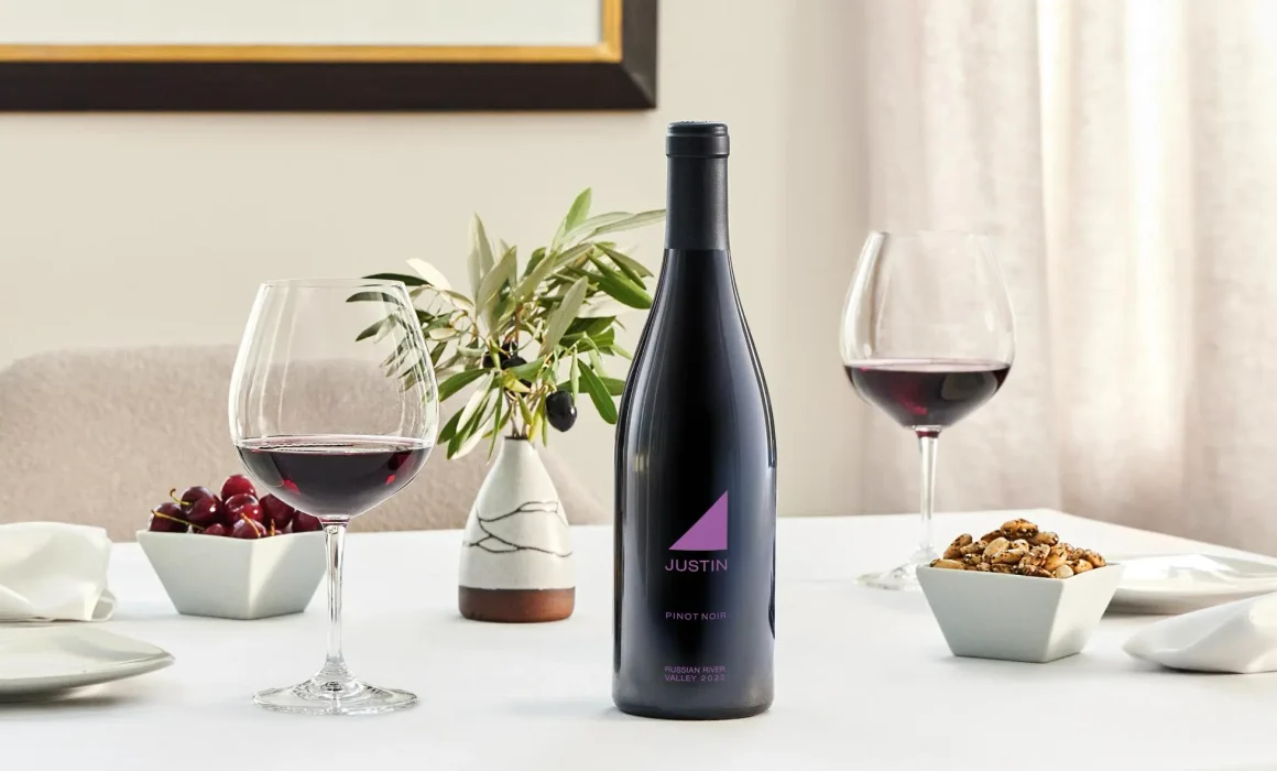 Bottle and two glasses of JUSTIN wine on a table