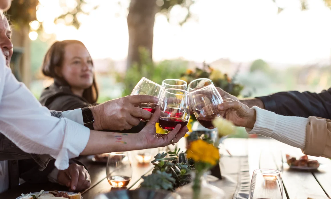 A group of friends cheers-ing their wine glasses